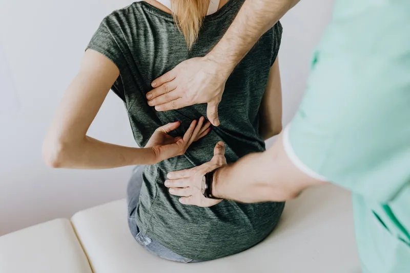 Clinician performing a hands-on stability assessment of a patient's knee