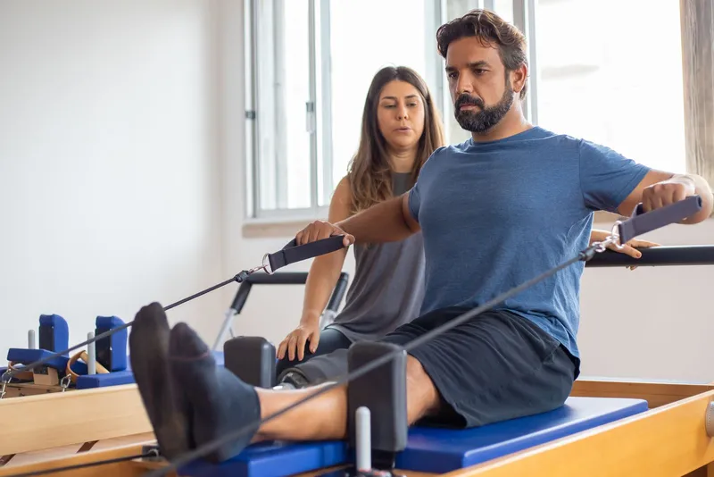 Patient working with a therapist on rehabilitation equipment